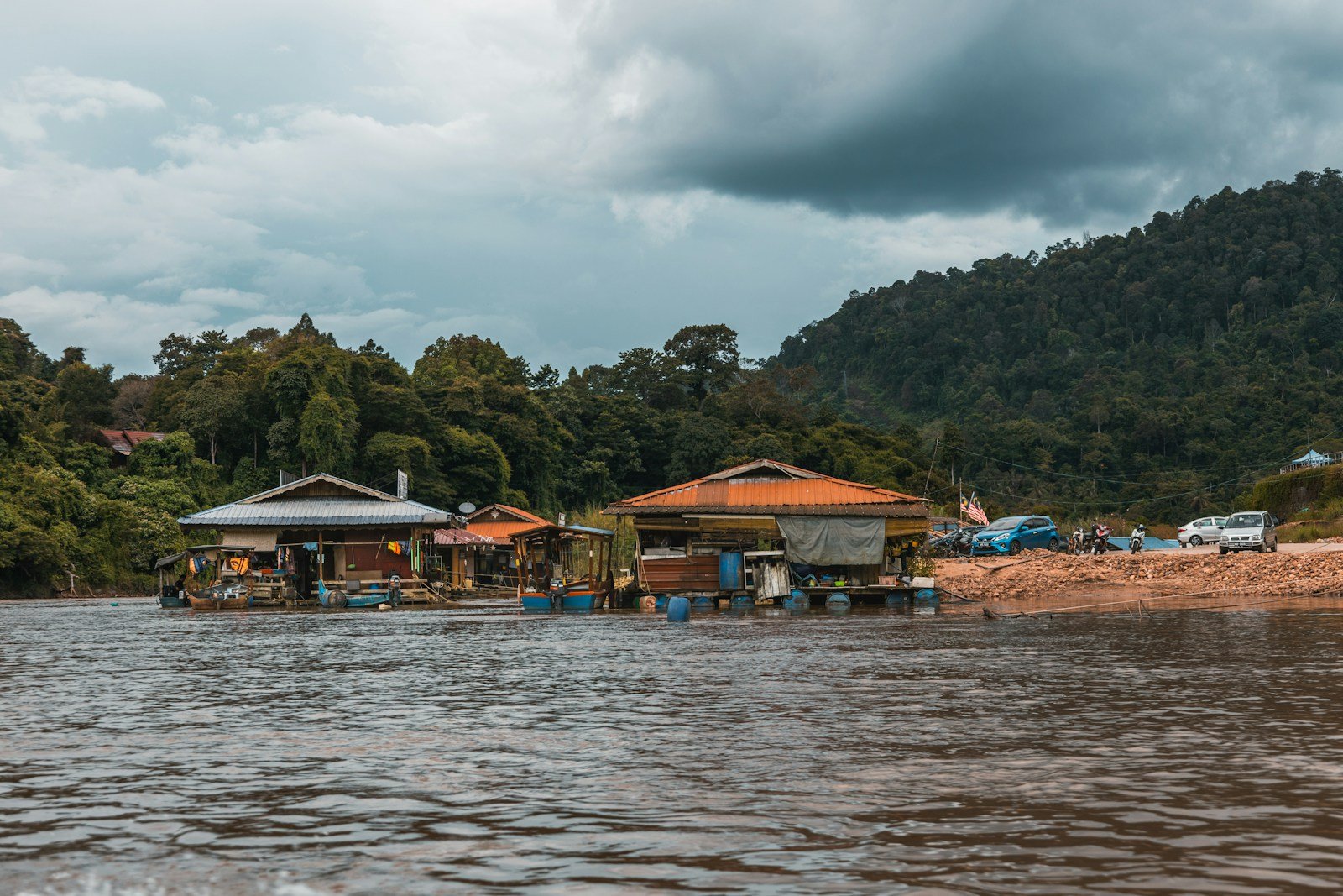 tall palm trees near sea with docks taken under white clouds
