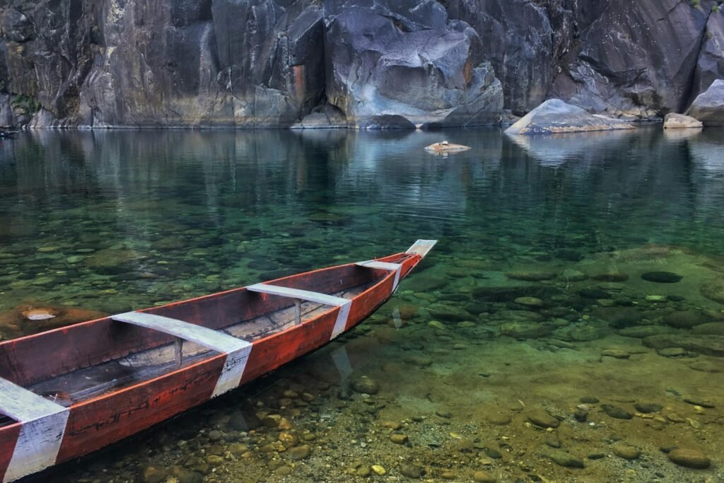 red and brown wooden boat on body of water during daytime